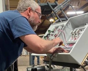 employee working with paint booth control panel